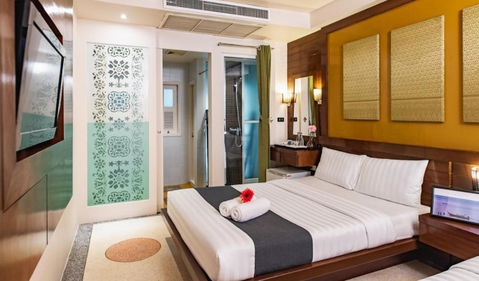 Traditional style hotel room with a queen sized bed at D&D Inn in Bangkok, Thailand