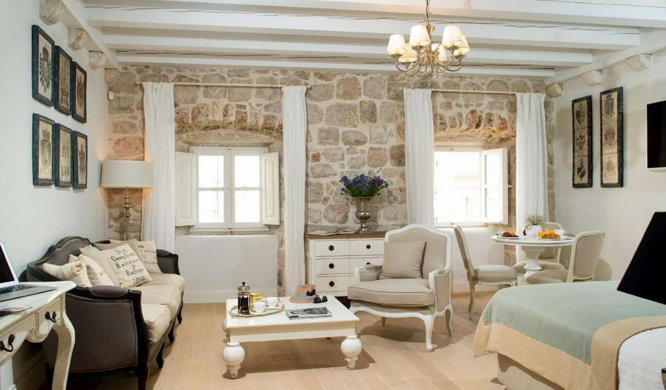 A large hotel room at St. Joseph's Hotel with exposed brick and pastel colors in Dubrovnik, Croatia