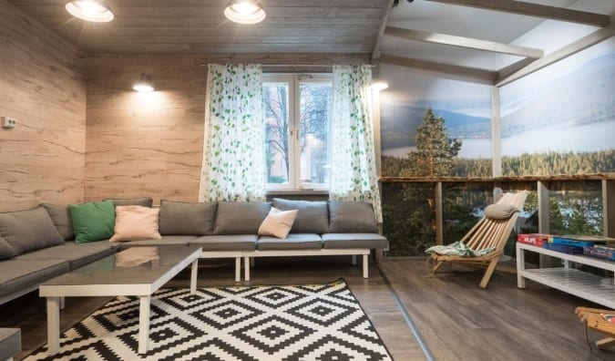 Common area at Eurohostel in Helsinki, Finland, with gray couches covered in big pillows and a large-scale photograph of a landscape adorning the walls
