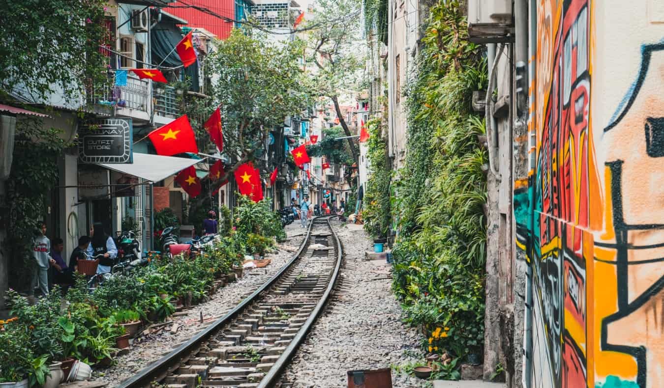 Train tracks running between close-together buildings in bustling Hanoi, Vietnam”/></noscript><br />
<a href=