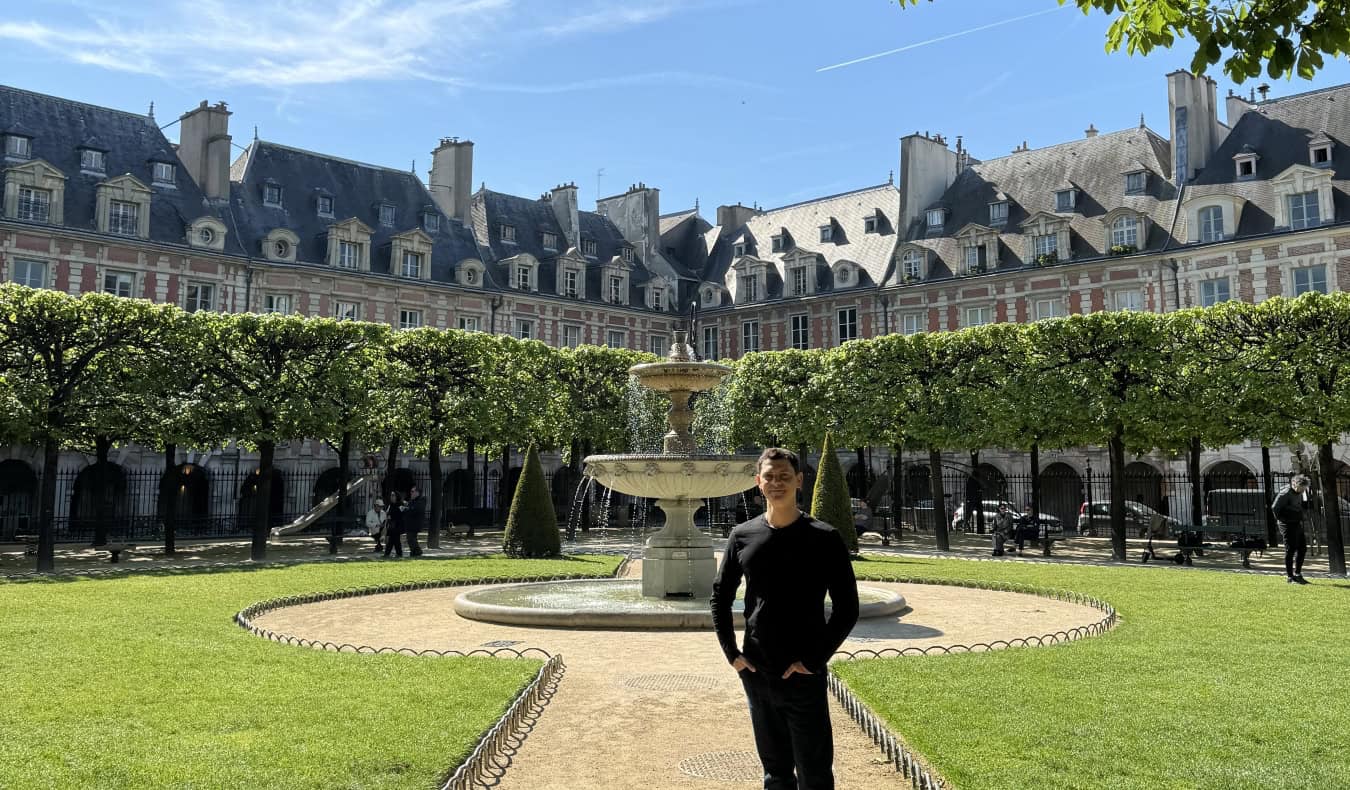 Nomadic Matt posing for a photo in Paris, France on a sunny summer day