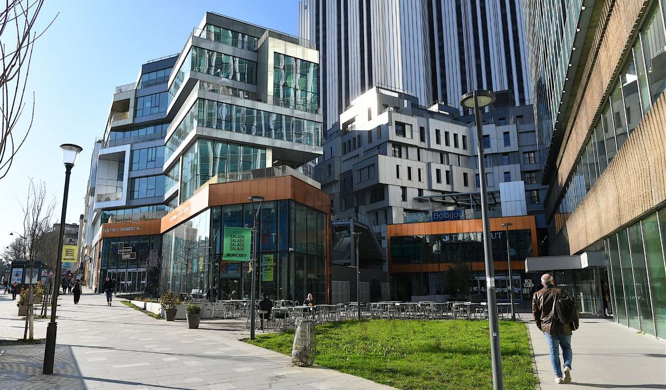 People passing in front of the Modern architectural building of the Ateliers Gaité shopping mall in the Montparnasse district of Paris, France