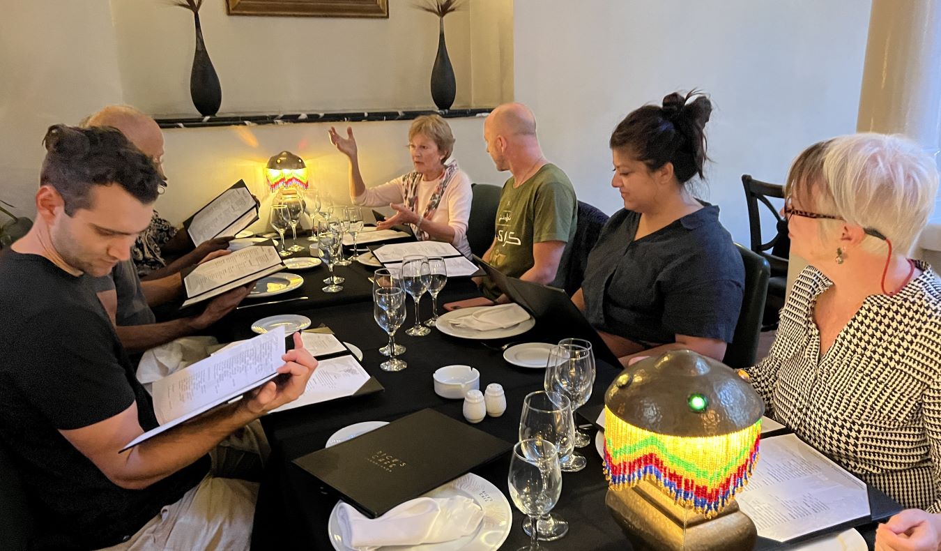 A group of people sitting and talking around a table at a restaurant